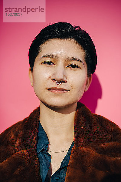 Porträt einer jungen Frau vor rosa Hintergrund