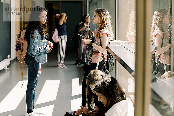 Studentinnen kommunizieren in der Mittagspause auf dem Schulkorridor
