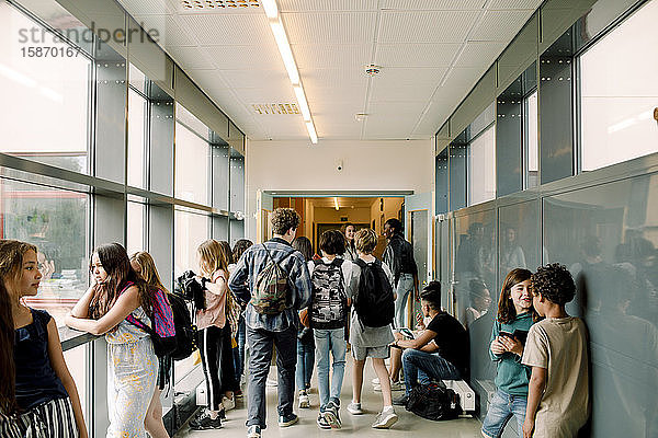 Rückansicht von Schülern  die während der Pause im Schulkorridor gehen