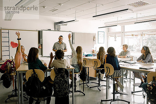 Männliche und weibliche Studenten mit Lehrer im Klassenzimmer