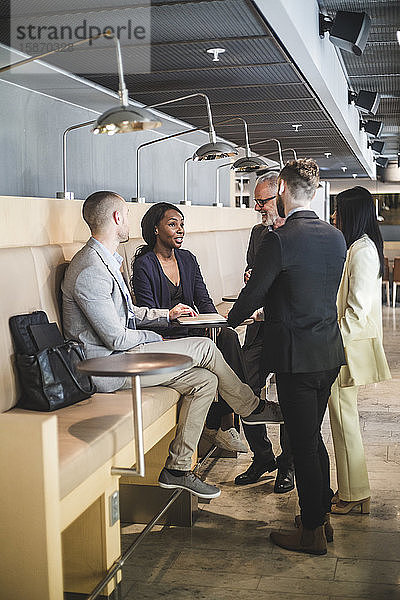 Männliche und weibliche Geschäftskollegen diskutieren während der Kaffeepause im Büro