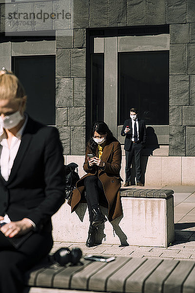 Geschäftsleute mit Gesichtsmasken halten soziale Distanz