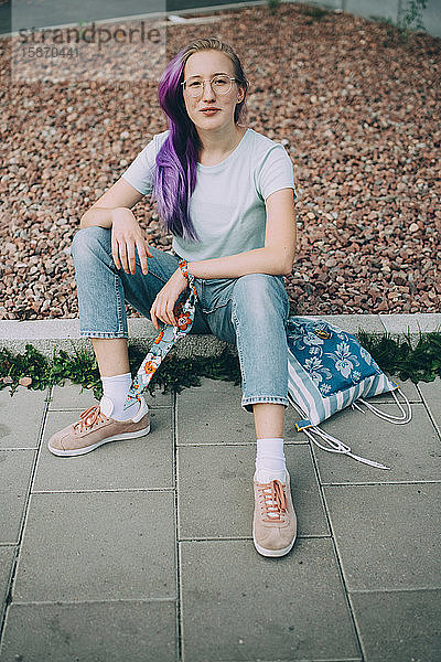 Porträt eines selbstbewussten Teenagers  der an Land sitzt