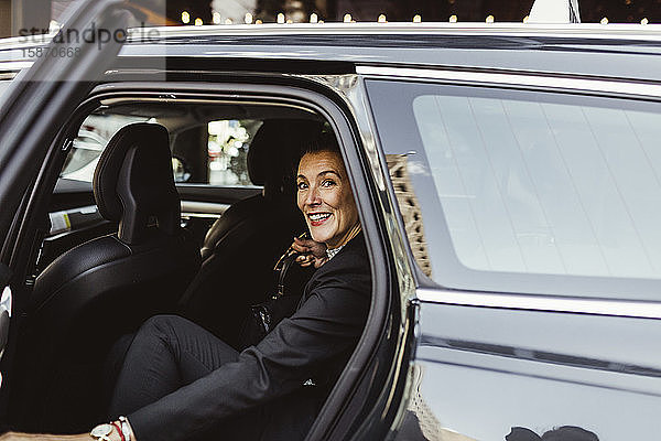 Porträt einer selbstbewussten Unternehmerin  die im Auto sitzt