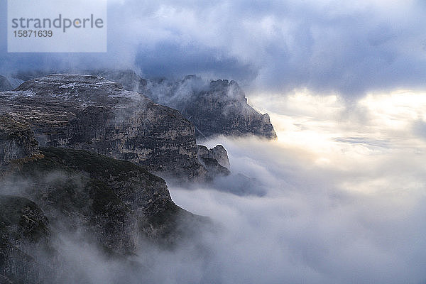 Sonnenlicht über der Croda dei Toni durch den Herbstnebel  der das Auronzotal bedeckt  Sextner Dolomiten  Trentino-Südtirol/Veneto  Italien  Europa