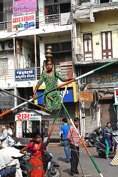 Junges Mädchen auf einem Drahtseil  das auf einer belebten Straße aufgebaut ist  um Geld zu verdienen  Ahmedabad  Gujarat  Indien  Asien