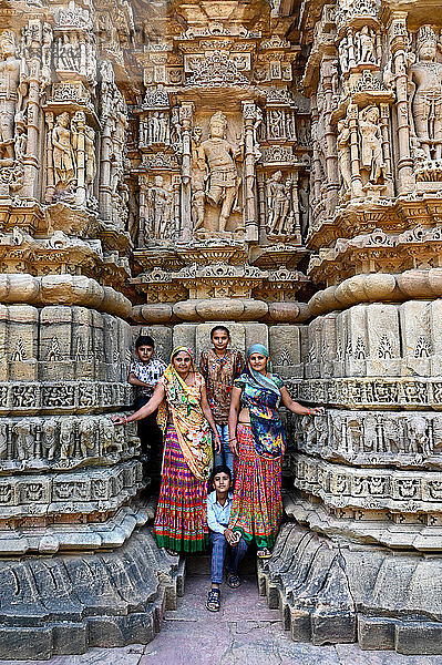 Familie posiert für ein Foto am kunstvoll geschnitzten Modhera-Sonnentempel  erbaut im Jahr 1026  Modhera  Mehsana  Gujarat  Indien  Asien
