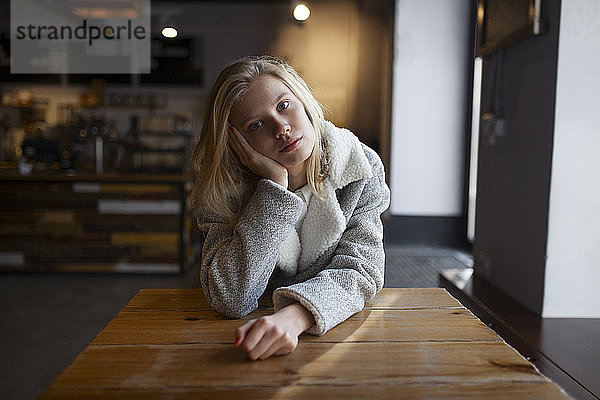 Junge Frau sitzt am Cafétisch
