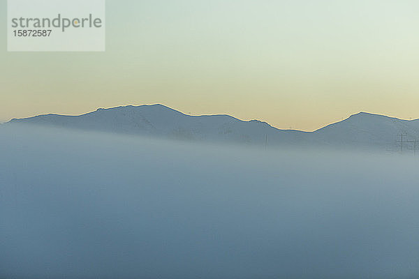 Berg im Nebel bei Sonnenaufgang