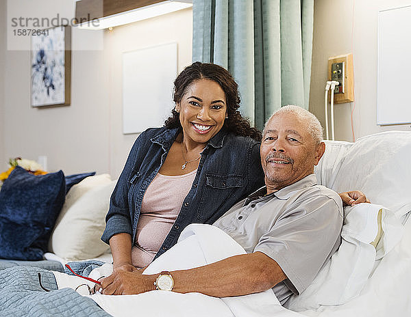 Lächelnde Frau und älterer Mann im Bett