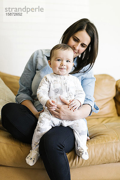 Porträt einer Mutter mit ihrem Sohn (12-17 Monate) auf dem Sofa sitzend