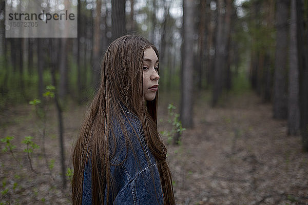 Junge Frau mit Jeansjacke im Wald