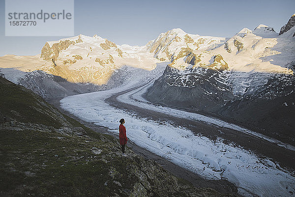 Frau steht auf einem Felsen am Gornergletscher im Wallis  Schweiz