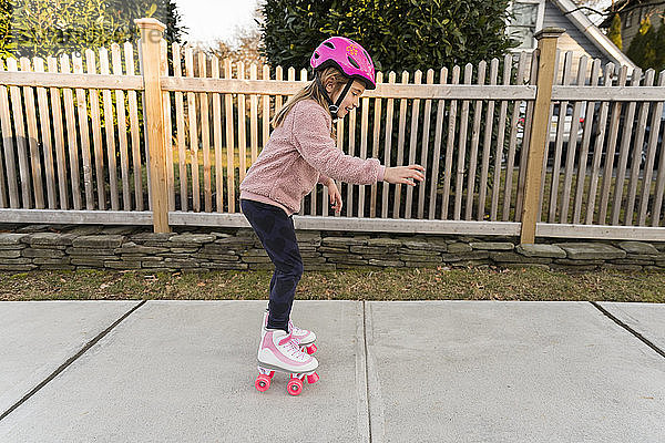 Mädchen lernt Rollschuhlaufen