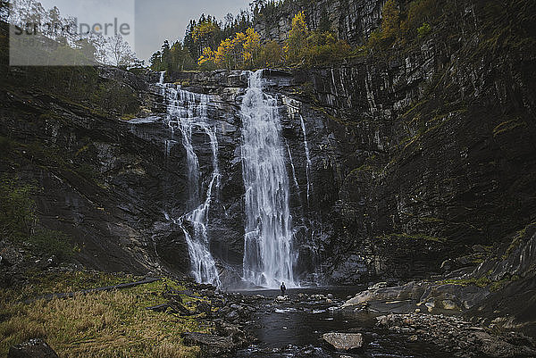 Person am Wasserfall Skjervefossen in Norwegen