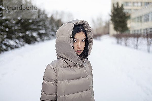 Junge Frau in Kapuzenjacke im Winter