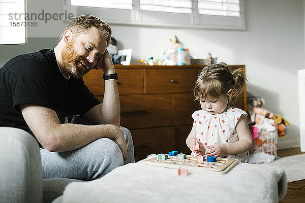 Vater beobachtet Tochter (2-3) beim SpielenÂ
