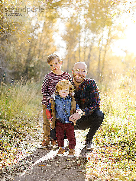 Lächelnder Mann mit seinen Söhnen auf einem Waldweg