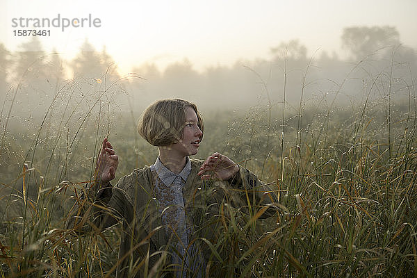 Junge Frau in einem Feld mit langem Gras
