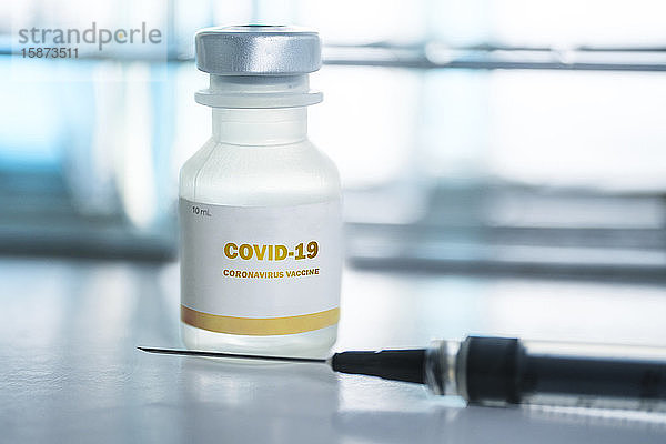 Fläschchen mit Covid-19-Impfstoff und Injektionsnadel