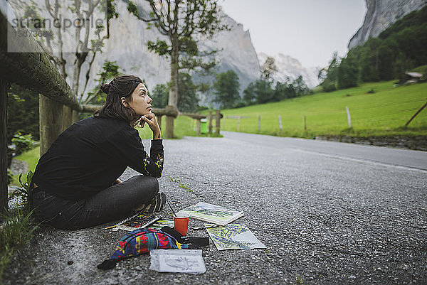 Junge Frau malt Berge auf der Straße