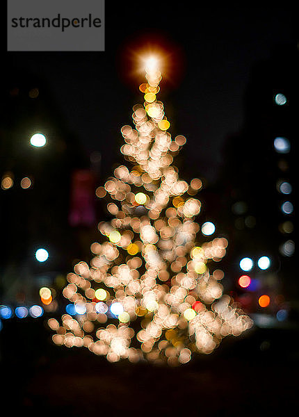 Unscharfer Weihnachtsbaum bei Nacht beleuchtet