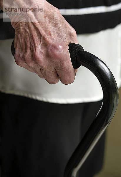 Nahaufnahme der Hand einer älteren Frau  die einen Gehstock hält