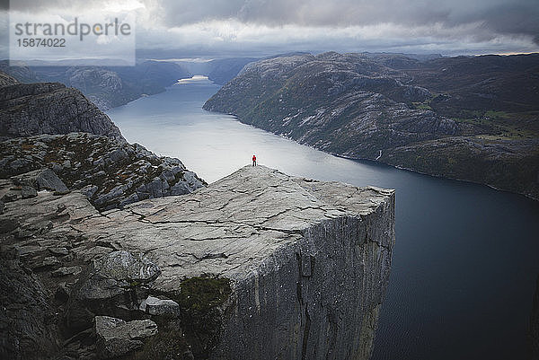 Stehende Person auf der Klippe Preikestolen in Rogaland  Norwegen