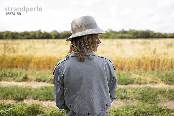 Junge Frau mit Filzhut in einem Weizenfeld