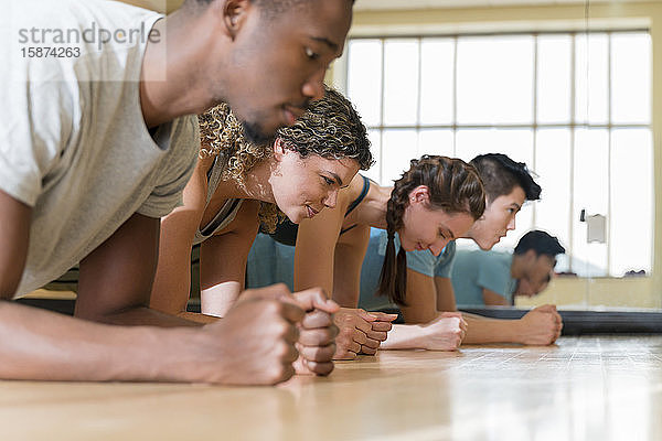 Eine Gruppe von Freunden macht Planken im SportunterrichtÂ