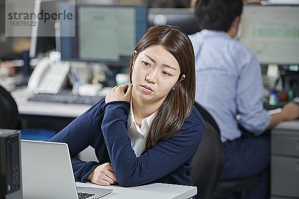 Müde japanische Geschäftsfrau im Büro