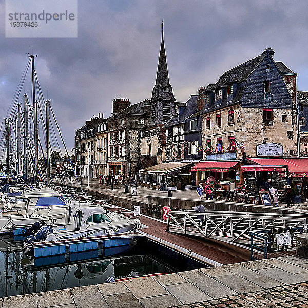 Honfleur  Calvados  Normandie  Frankreich. Honfleur liegt an der Mündung der Seine  in der Nähe der berühmten Normandie-Brücke. Honfleur ist berühmt für seinen malerischen Hafen mit seinen bunten Gebäuden und Häusern mit schiefergedeckten Fronten. Der Hafen von Honfleur wurde von vielen Künstlern gemalt  die die impressionistische Bewegung begründeten: Claude Monet  Gustave Courbet und EugÃ¨ne Boudin.