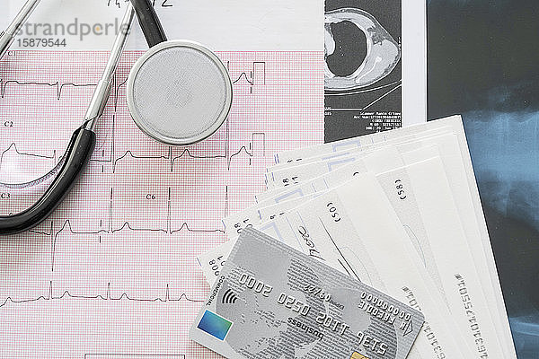 Nahaufnahme von Stethoskop  Kreditkarte und Schecks auf medizinischen Berichten