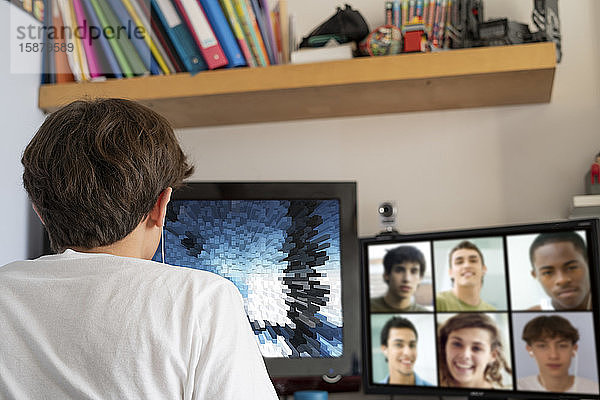 Jugendlicher  der zu Hause mit seinen Freunden am Computer videochattet