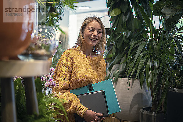 Junge Frau steht in einem Blumenladen