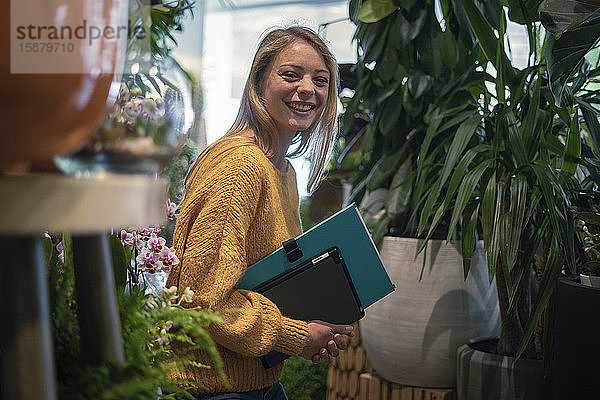 Junge Frau steht in einem Blumenladen