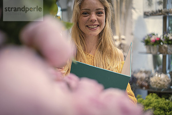 Junge Frau hält Akte in einem Blumenladen