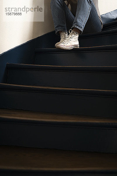 Junge Frau sitzt auf einer Treppe