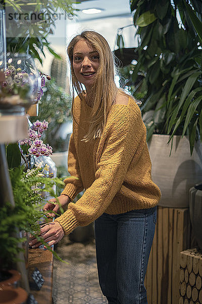 Junge Frau steht in einem Blumenladen