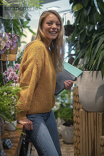 Junge Frau steht in einem Blumenladen