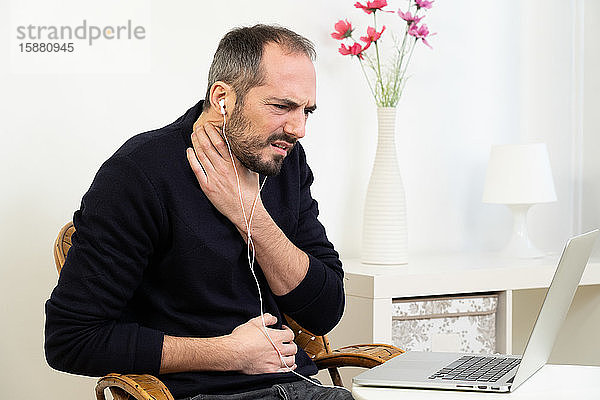 Ein Mann mit Halsschmerzen konsultiert seinen Arzt per Videokonferenz.