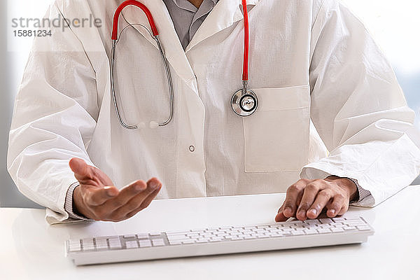 Arzt mit einem Stethoskop auf dem Laptop-Bildschirm. Konzept der Telemedizin oder Telegesundheit