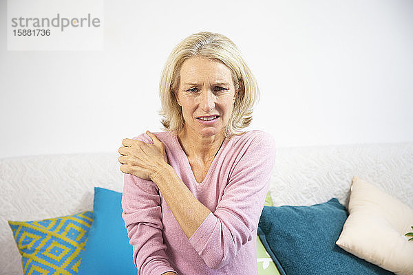 Eine Frau in den Fünfzigern mit Schulterschmerzen.