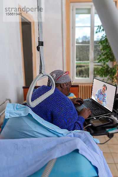 Die Geschäftsfrau macht während ihres Krankenhausaufenthalts zu Hause weiter ihre Hausaufgaben. Im Bett bleiben und Internet-Konsultation mit ihrem Arzt führen