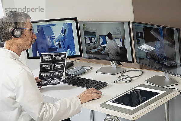 Gynäkologe während einer Videokonsultation mit einem Radiologenkollegen für die Brustuntersuchungen einer Patientin: Mammographie und Ultraschall.