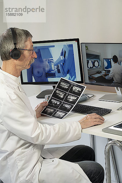 Gynäkologe während einer Videokonsultation mit einem Radiologenkollegen für die Brustuntersuchungen einer Patientin: Mammographie und Ultraschall.
