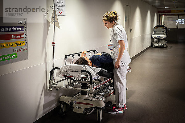 Eine Krankenschwester diskutiert mit einer Patientin  bei der sich die Karte in einer Tasche befindet.