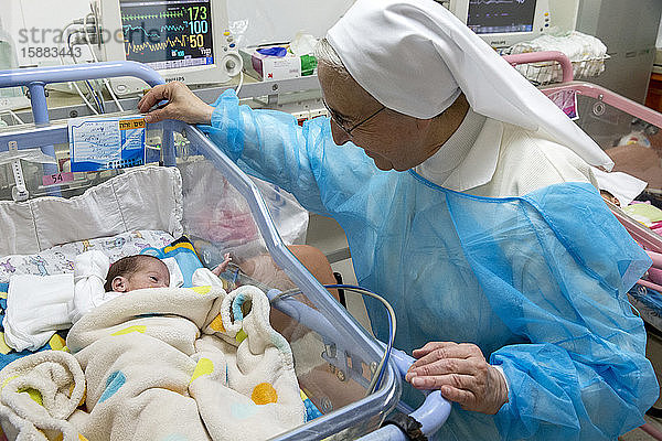 St.-Vincent-de-Paul-Krankenhaus  betrieben von den katholischen Missionarinnen der Töchter der Nächstenliebe in Nazareth  Israel. Neonatologische Station. Nonne schaut sich ein Frühchen an.