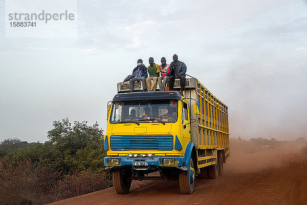 Lastwagen auf einer staubigen Straße in Burkina Faso.