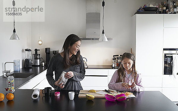 Privatleben  ein Schulvormittag während des Einschlusses. Ein Mädchen und seine Mutter in einer Küche beim gemeinsamen Kochen